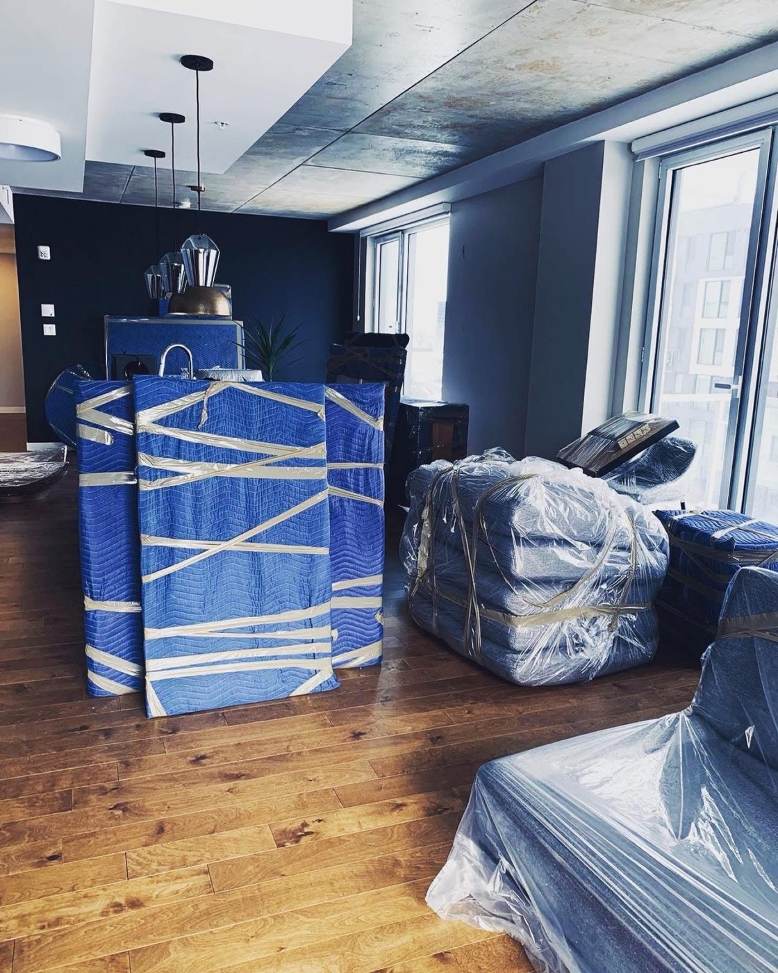 Mattresses and chairs covered with blue pads in a condo.