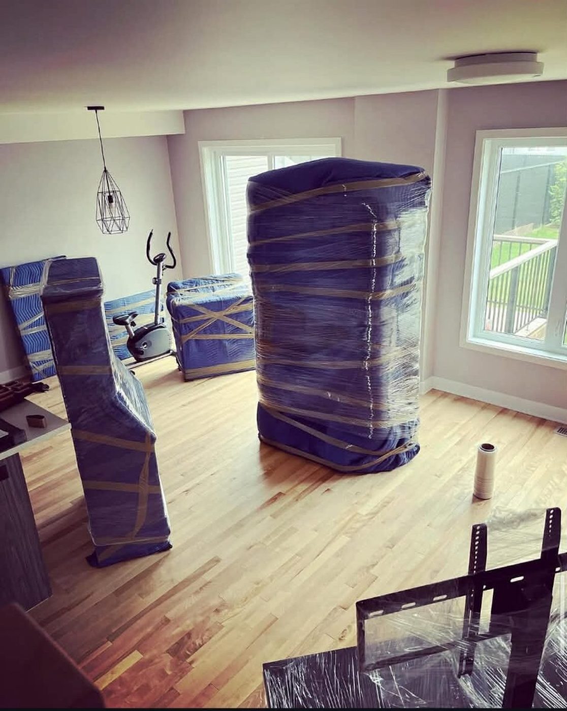 Furniture fully covered in a living room with a wood floor.